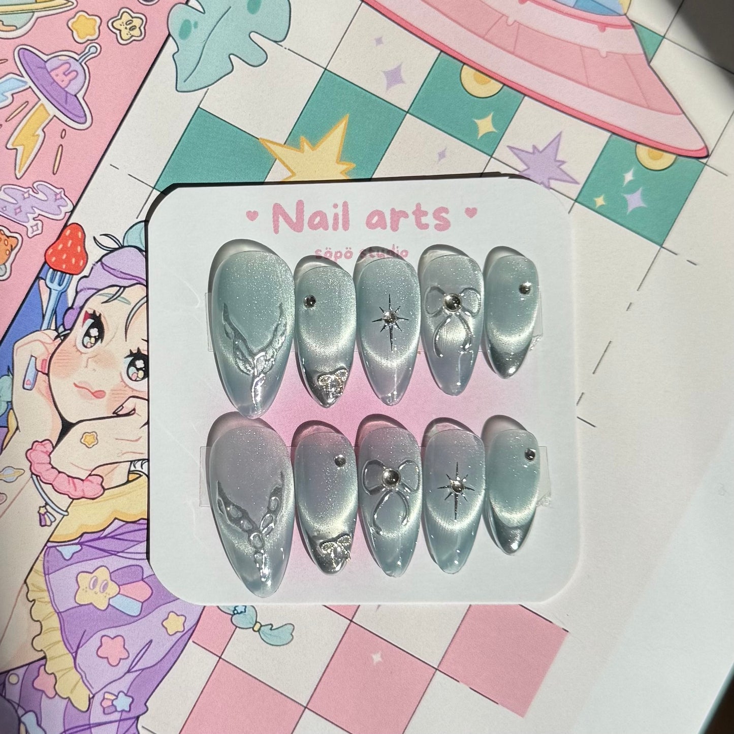Set of nail art decorations in a clear plastic case on a colorful background