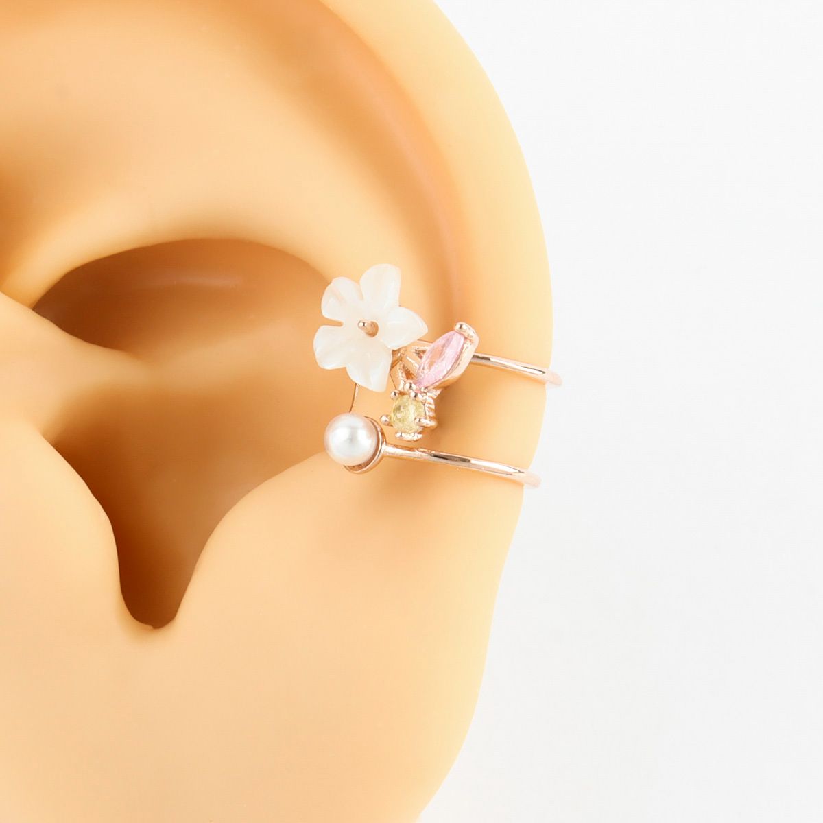 Floral earring with pearl detail on a white background