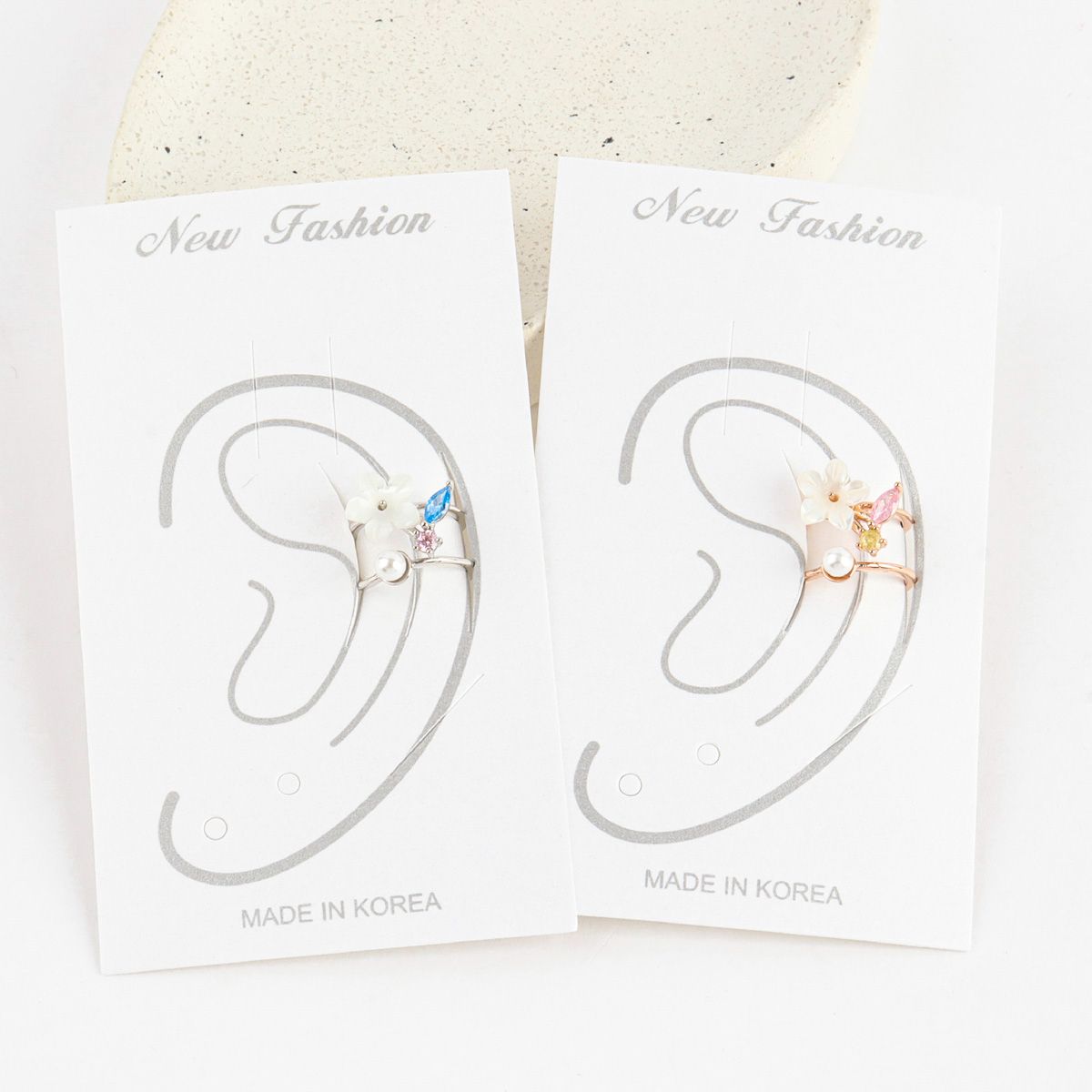 Two pairs of earrings on display with 'New Fashion' labels on a white background.