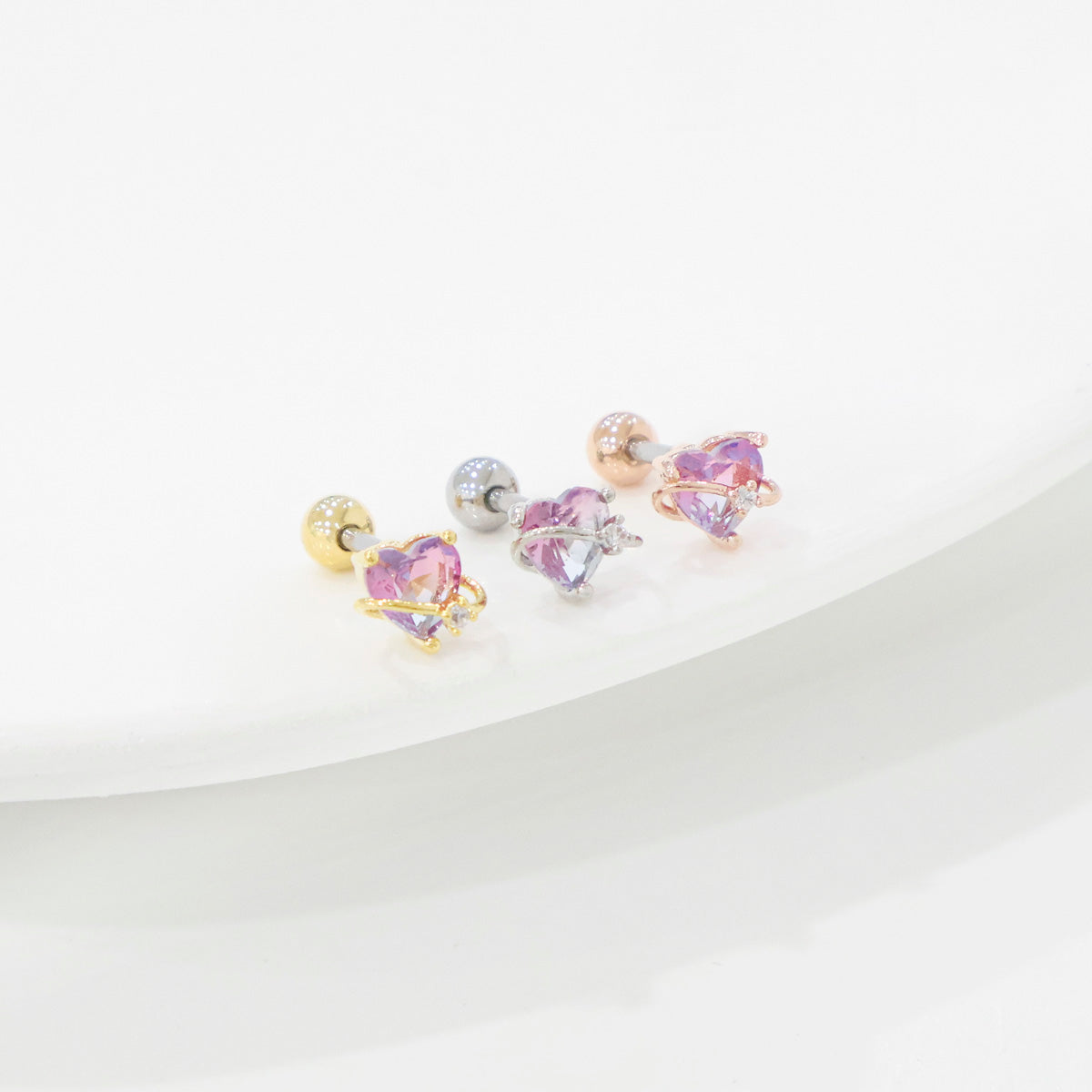 Set of three earrings with colorful gemstones on a white background