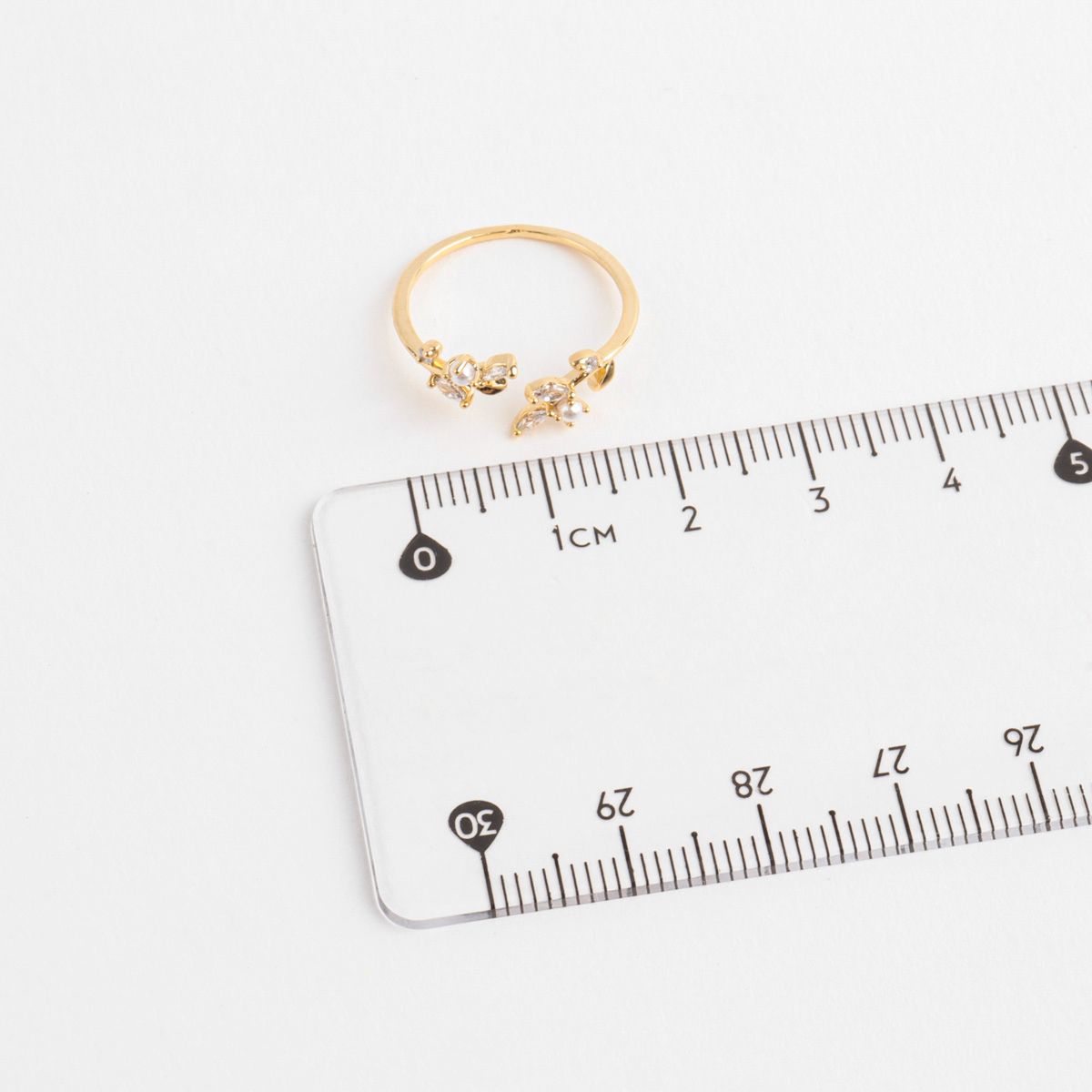 Gold ring on a clear plastic ruler with measurement markings