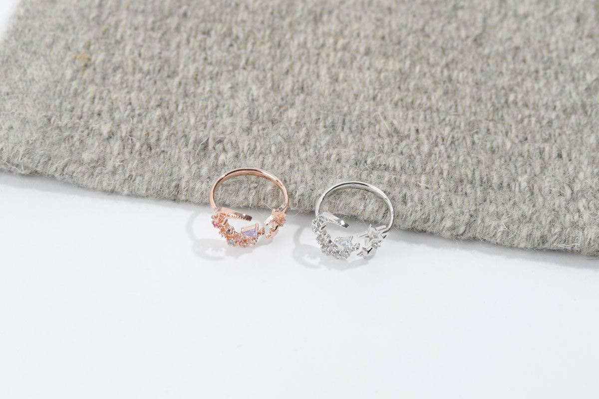 Two small hoop earrings on a textured gray surface